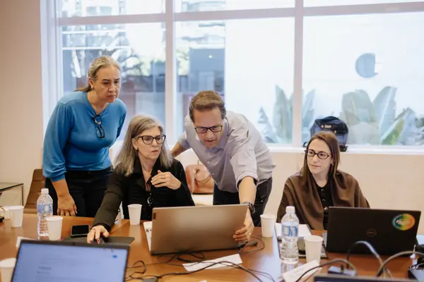 Mediadores acompanham um grupo em frente ao notebook