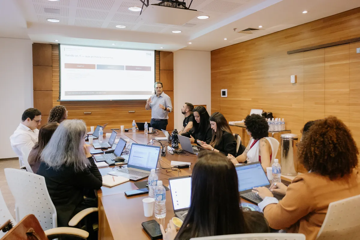 Turma do IA RH Brasil em sala, com os participantes nos notebooks e um mediador apresentando ao fundo